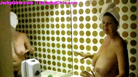 Naked mature MILF with huge natural tits posing in bathroom mirror