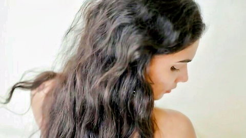 Stunning Indian bimbo with long wavy dark hair, topless side profile view
