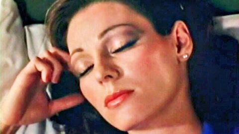 Annette Haven lying seductively on bed in vintage 80s porn scene