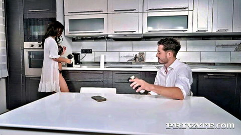 Skinny brunette in sheer white robe exposing ass in kitchen to seated man