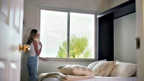 Skinny blonde teen with medium tits in tight white tank top and jeans looking out bedroom window