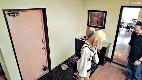 Blonde woman in white sweater and black restraints bending over with watching man
