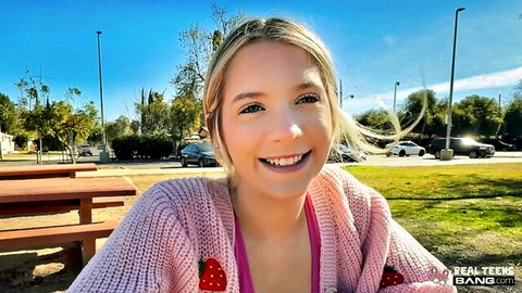 Becky Summer blonde teen smiling in pink strawberry cardigan outdoors
