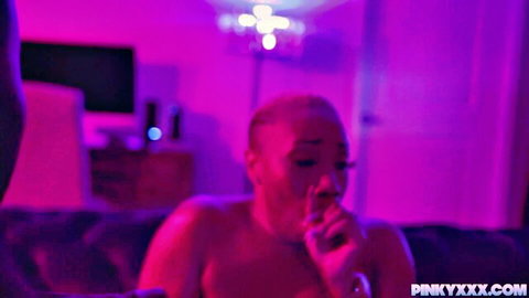 Ebony Mystique nude, smoking seductively in dim light