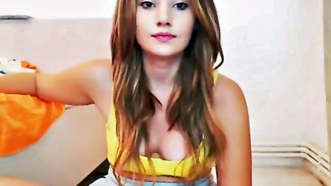 Brunette babe in low-cut yellow top flashing cleavage and teasing smile
