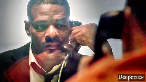 Intense BBC black man in suit holding phone to ear dramatically