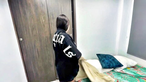 Clothed Asian babe in oversized black ACID LS hoodie standing by bed in amateur bedroom
