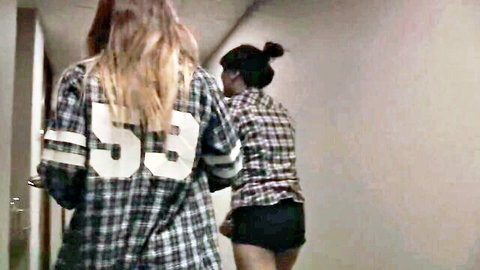 Blonde and Asian teens in jersey and plaid outfits from behind