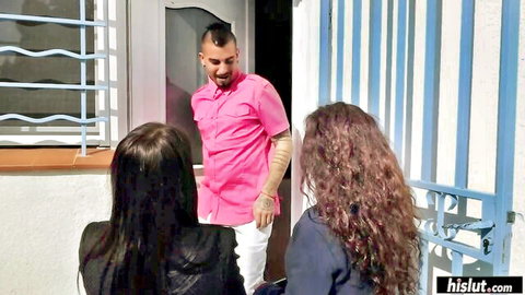 Two brunettes greet handsome man in pink shirt at outdoor gate entrance
