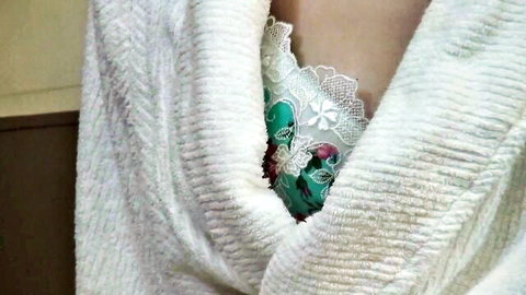Asian woman teasing cleavage in green lace lingerie under open white robe