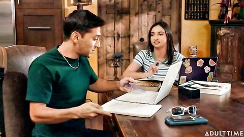 Young Latina woman and Hispanic man reviewing laptop files at table