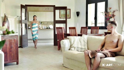 Sybil in sexy towel after shower, teasing shirtless hunk on couch X-Art