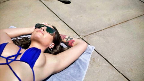 Desiree Dulce relaxing in blue bikini, sunbathing poolside