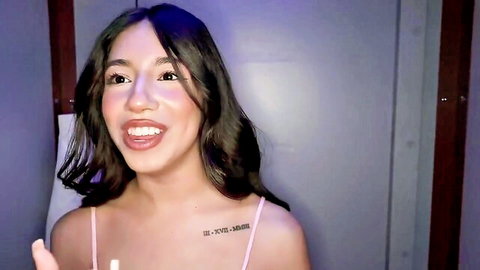 Camila Cream smiling in pink tank top, tattoo visible
