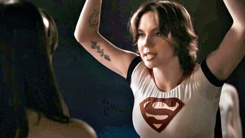 Powergirl in superhero costume raising arms with Wonder Woman in adult domination scene