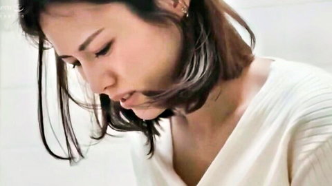 Seductive Asian woman with short brown hair in white sweater, close-up