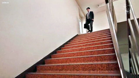 Asian businessman in suit ascending red stairs in hallway