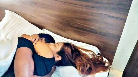 Naughty couple cuddles intimately in bed for morning kissing session