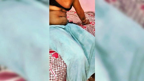 Curvy Indian woman in black bra and low pants exposing soft belly and navel on bed