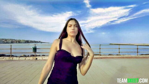 Shelena curvy Italian teen in low-cut purple dress on seaside walkway