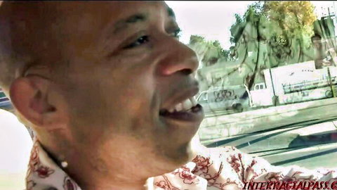 Smiling black man in floral shirt driving car, interracial adult preview