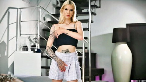 Tattooed blonde babe in black top and tiny white pleated skirt posing seductively