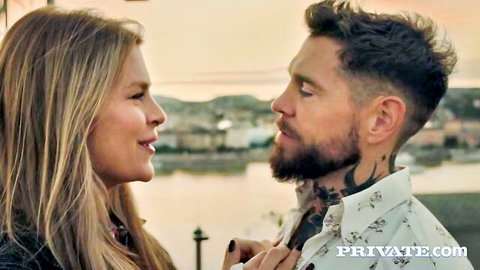 Blonde babe passionately kissing tattooed hunk on romantic rooftop at sunset