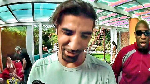 Bearded man smiles with black guy and bikini-clad women at lively pool party