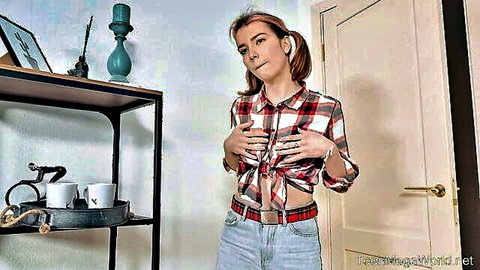Cute teen with pigtails teases in tied checkered shirt and jeans