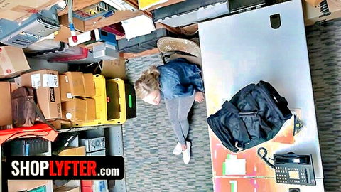 Blonde skinny shoplifter lying on office floor surrounded by boxes in tight jeans and top