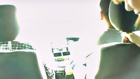 Blurry green-tinted POV from car backseat showing clothed driver gripping steering wheel at night
