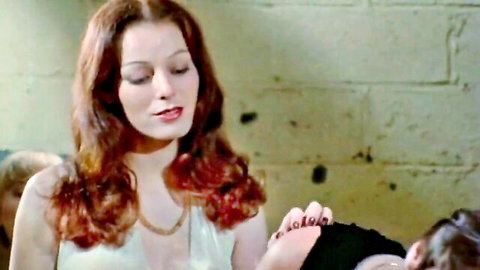 Vintage redhead in sheer white dress touching hand in 1978 porn scene