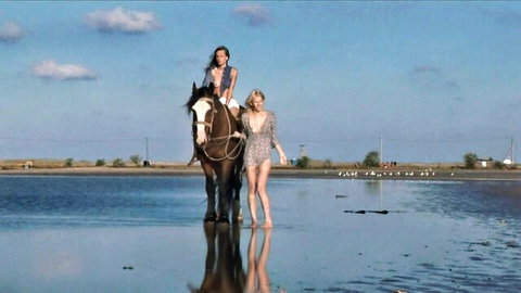 Katy and blonde model posing on horse in wet lace dress at beach