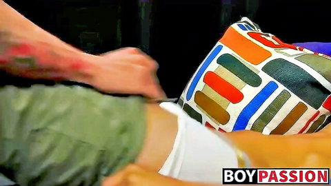 Tattooed hand pulls down twink's white underwear exposing his bare ass on colorful pillow