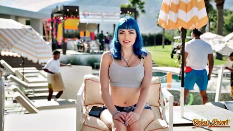 Skinny blue-haired babe with perky nipples poking through braless tank top sitting poolside