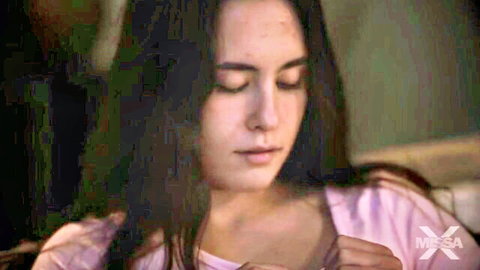 Closeup of seductive brunette beauty with long hair in pink top gazing intensely