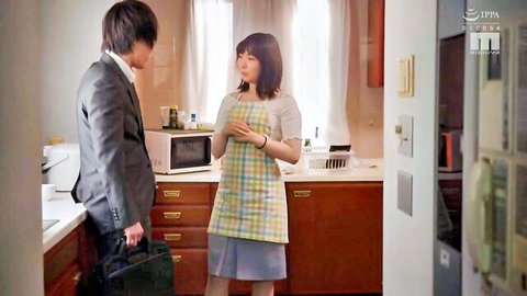 Japanese businessman chats with cute colleague in apron and skirt in home kitchen