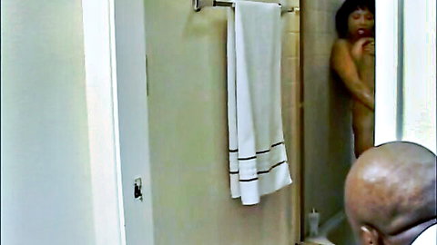 Nude black woman in shower covers body as bald man watches post-shower oral tease