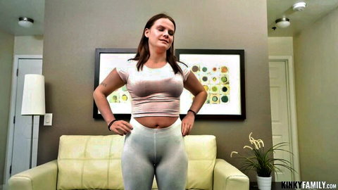 Brunette curvy babe in tight white crop top and leggings posing hands on hips flaunting big tits and thick ass