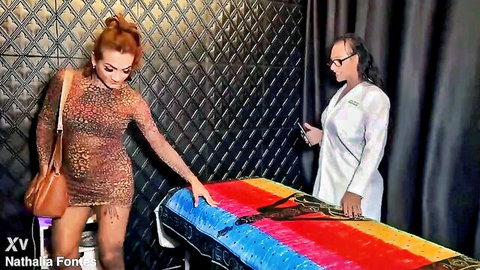 Curvy brunette in sheer leopard dress bends over colorful exam table for doctor