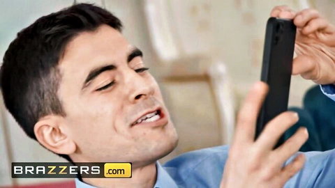 Handsome man smiling while holding phone for selfie in Brazzers video