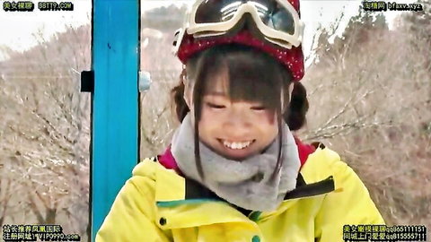 Cute smiling Asian girl in yellow ski jacket and goggles smiling outdoors