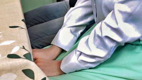 Mayu Suzuki in shiny silver blouse and jeans, legs up in teasing JAV pose