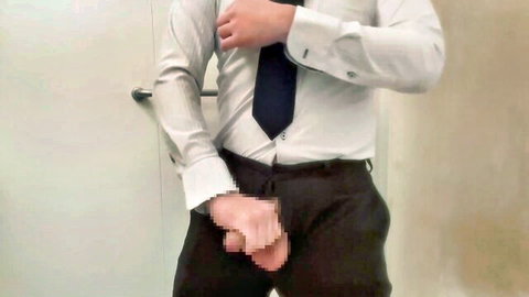 Suited businessman gropes his hard cock bulge through pants in bathroom mirror selfie