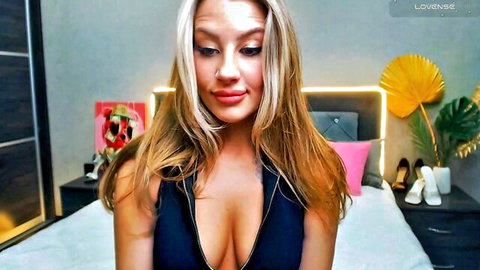 Blonde camgirl Magic_Eyes teasing cleavage in black zip-up top