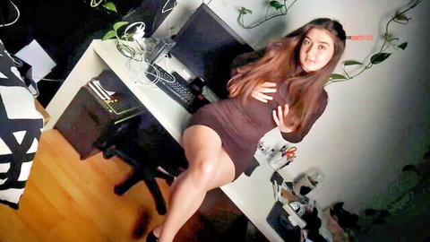 LeahSnuSnu teasing in short brown dress, hands on chest, long hair