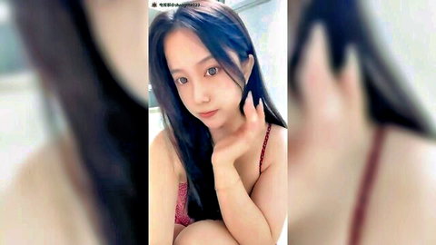 Cute young East Asian babe teasing huge tits cleavage in red lingerie peace sign selfie