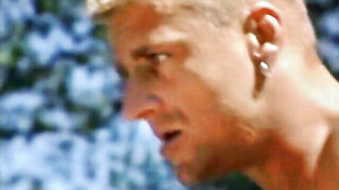 Closeup of intense blonde man with earring staring sideways in profile view