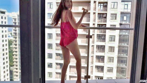 Olya Derkach in pink lingerie posing seductively on balcony