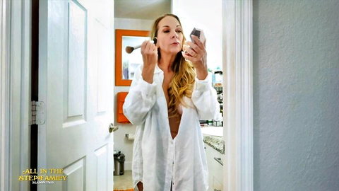 Blonde MILF with big tits exposes bare breasts in open robe applying makeup selfie
